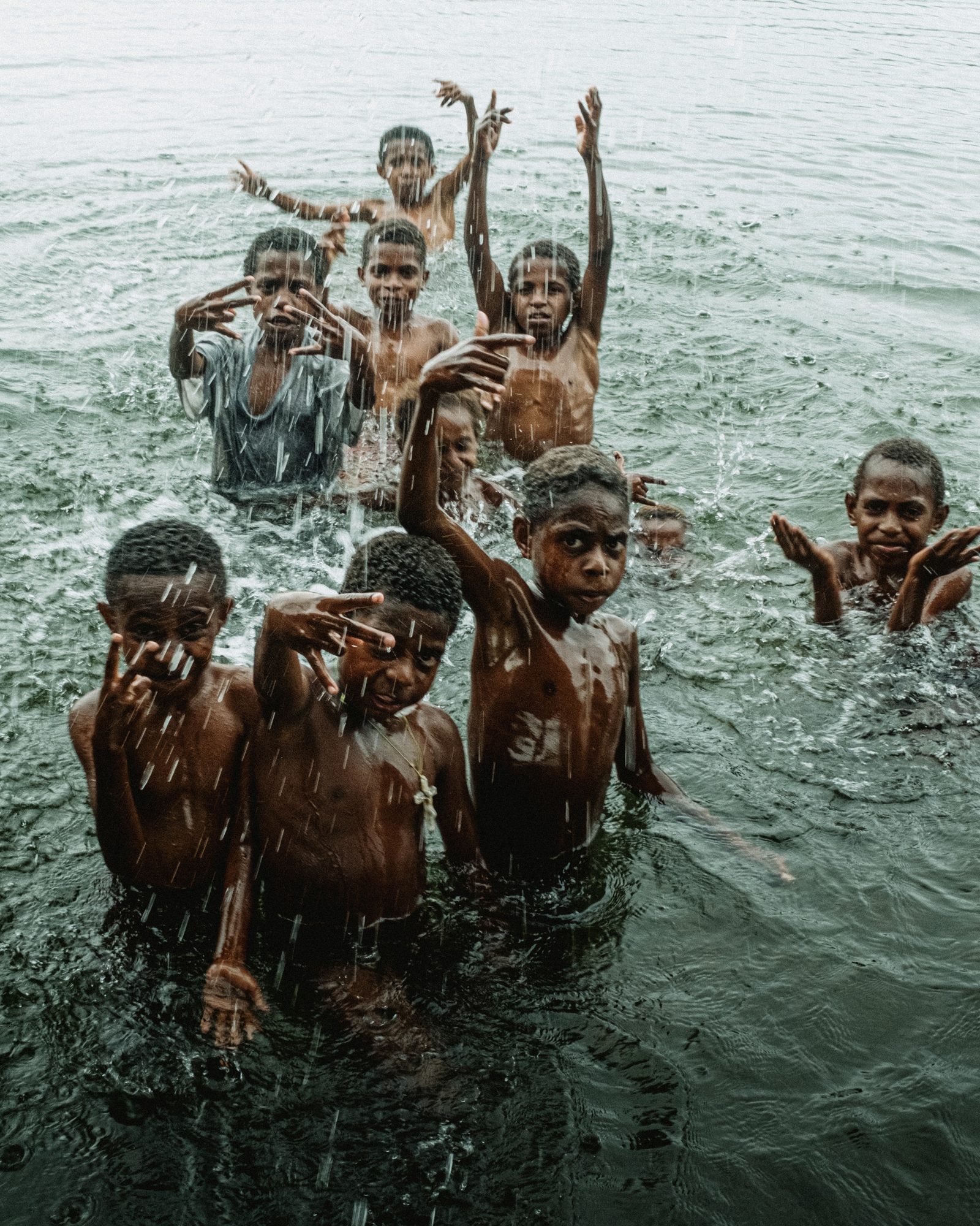 Children splash and wave from the water